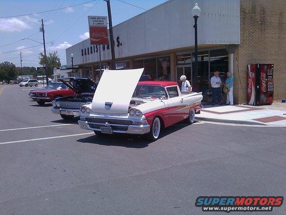Two-tone red and white 1958 Ford Ranchero with hood open, parked on street