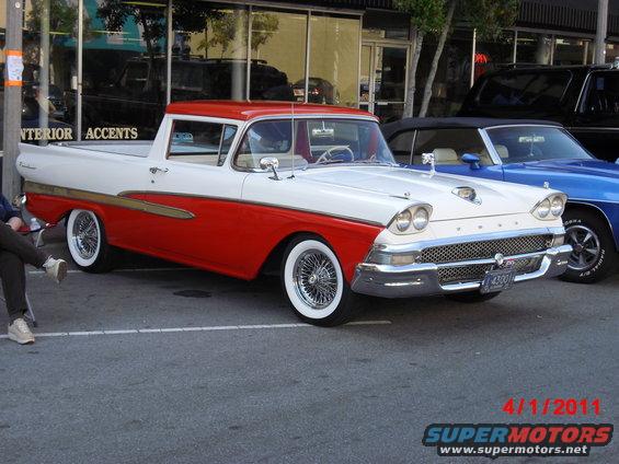 1958 Ford Ranchero two-tone red and white with wire wheels parked next to a blue car