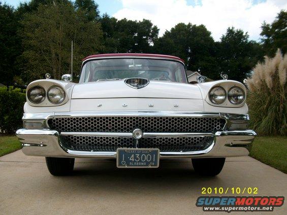 Front view of a white 1958 Ford Fairlane with a red roof and Alabama license plate