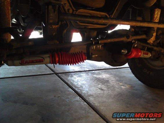 Underside of a vehicle showing a red-booted steering stabilizer with 'Ranger' branding