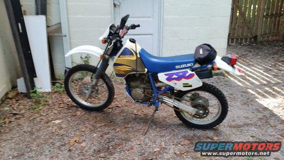 1993 Suzuki DR350S motorcycle parked outside next to a building