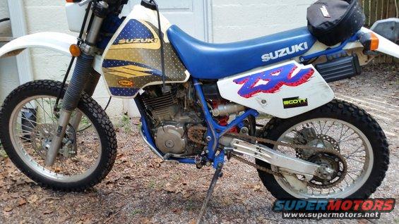 White and blue 1993 Suzuki DR350S motorcycle parked on dirt, side view