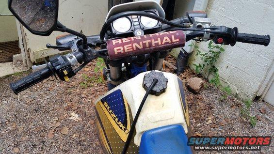 Motorcycle fuel tank with SUZUKI logo and Renthal handlebars