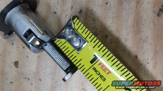 Motorcycle suspension part measured with tape measure
