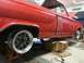 1964 Ford Fairlane - A red 1964 Ford Fairlane is shown on jack stands, possibly during a restoration, with new wheels installed.