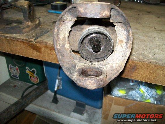 Close-up of a rusty, damaged suspension part on a workbench