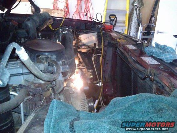 Engine bay with tools and a teal towel covering parts