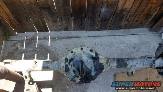 Rear axle assembly with differential cover, under wooden planks