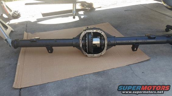 Ford rear axle assembly with differential cover removed, sitting on cardboard