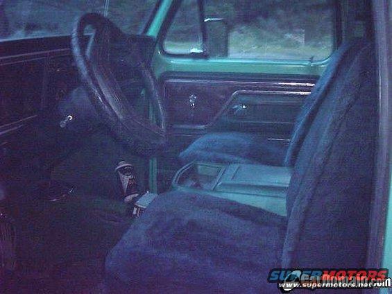 Interior shot of a green vehicle, showing the steering wheel, dashboard, and seats