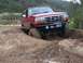 1996 Ford Bronco - Red 1996 Ford Bronco tackling a challenging muddy terrain during an off-road excursion.