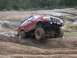 1996 Ford Bronco - A red 1996 Ford Bronco tackles a challenging muddy off-road course.