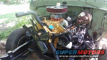 Engine bay with V8 engine, air cleaner, and fan. Supermotors.net logo visible