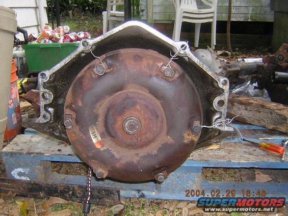 rusted torque converter and transmission housing sitting on a pallet outside