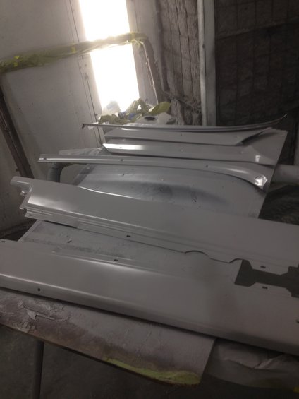 Shelves holding various car parts, possibly for a restoration project