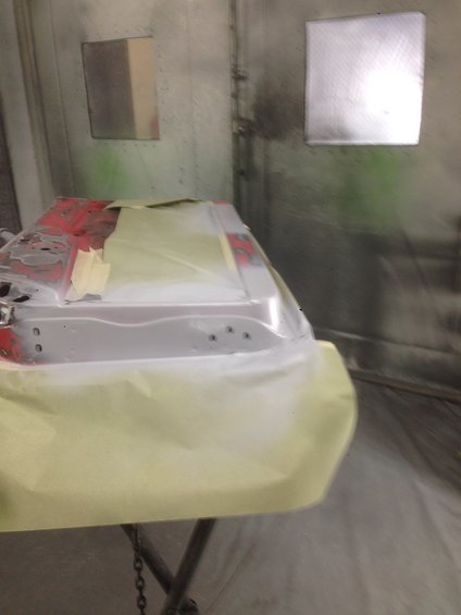 Car door covered in masking paper in a paint booth