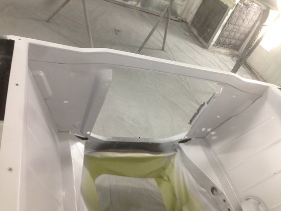 White car interior, masked for painting, showing firewall and dashboard area