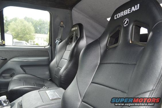 Interior view of truck with two black Corbeau racing seats and a center console