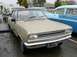 1969 Lincoln Continental - A tan sedan with a black roof is parked next to other vehicles, with its license plate clearly visible.