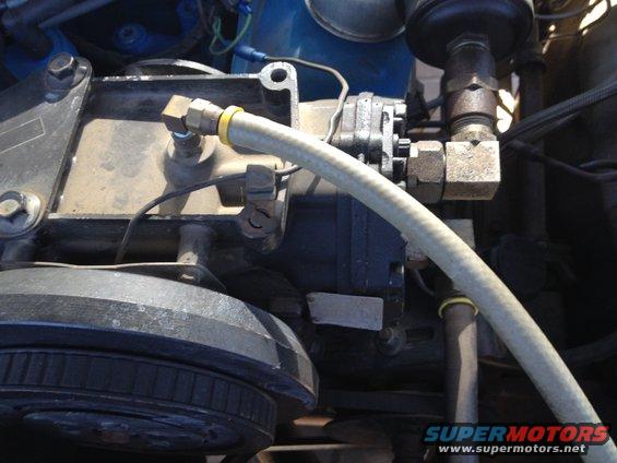 Close-up of a vehicle's engine compartment showing a pump and hoses
