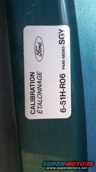 Ford oval logo on a white sticker with French and English text, and a part number