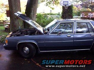 Gray sedan, hood open, side view. Watermark: SUPERMOTORS.NET