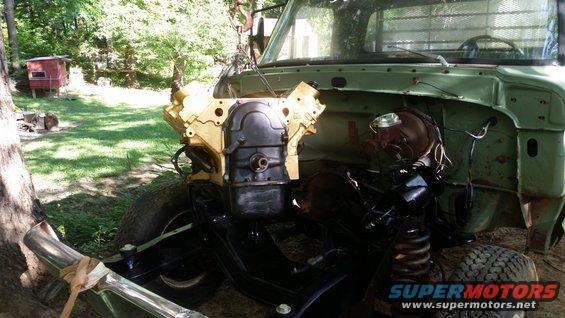 Truck with engine removed, showing the engine bay and frame. Some parts are painted yellow and black