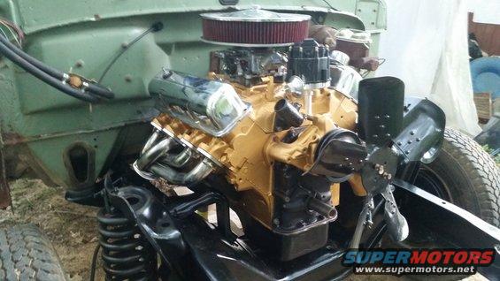 Gold engine with chrome valve covers and headers in engine bay