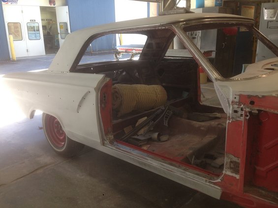 1964 Ford Fairlane body, primer white, undergoing repairs, interior stripped, red inner panels visible