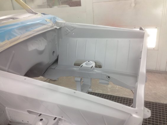 Car chassis interior, appears to be prepped for paint. Some blue masking tape is visible