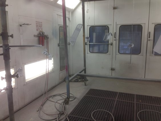 Paint booth interior with spray guns and hoses
