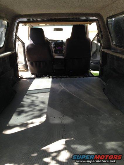 View from inside a pickup truck bed looking into the cabin, showing the seats and dashboard