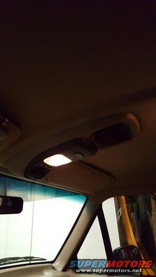 Interior overhead console with illuminated light and storage compartments