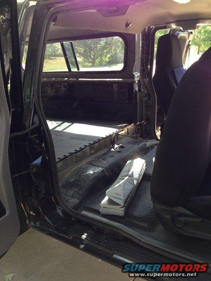 Interior of a truck bed with seats and a folded mat