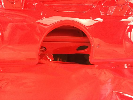 red painted car part with an arched opening