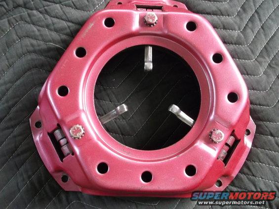 Red clutch pressure plate with three spring-loaded levers visible through the center opening