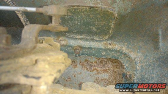 Factory cut out plate located, bottom of truck and looking up. Two large threaded holes on transmission are for the shift bracket mounting bolts.