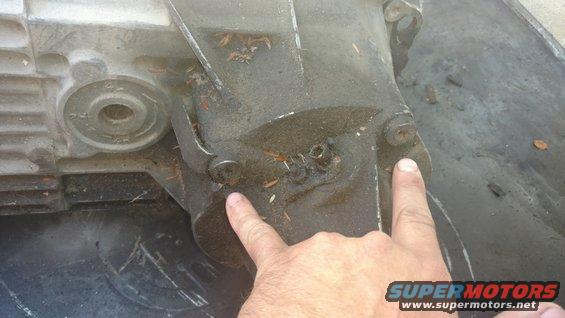 Pointing at 2 of the 4 bolts holding the tail housing on for the Manual case. These torx bolt will have to be removed to gain access to internals and make the swap.
