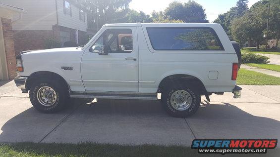 White 1995 Ford Bronco parked on a concrete driveway, side view