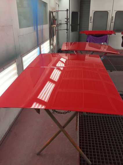 Red car hood in paint booth