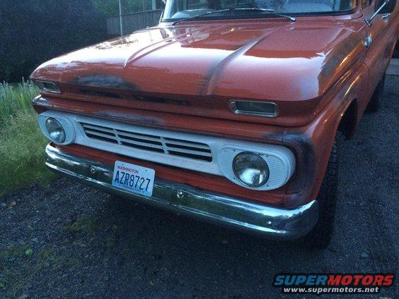 Orange pickup truck front end with white grille and Washington license plate AZR8727