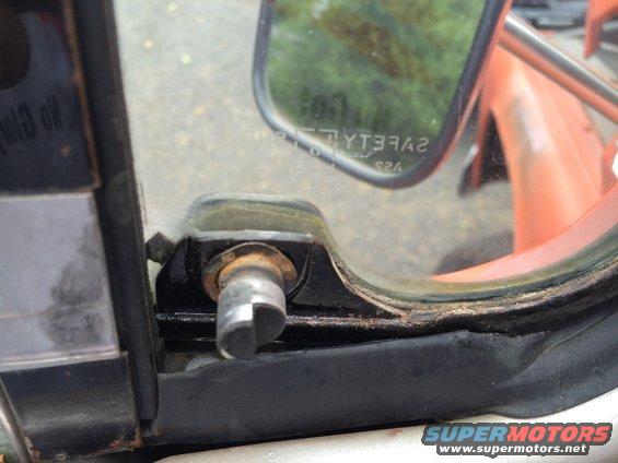 Close-up of a vehicle's interior door lock mechanism and side mirror frame