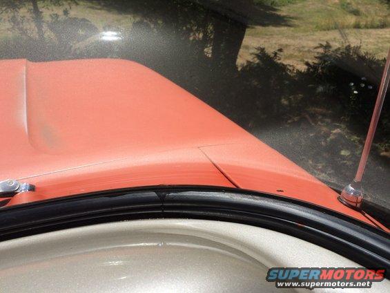 Orange hood and windshield frame with black rubber seal and chrome antenna base