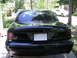 2003 Mercury Marauder - Rear view of a black 2003 Mercury Marauder sedan. The vehicle is parked outdoors with trees and another car in the background.