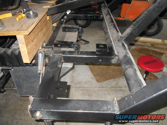 Metal frame structure with wooden support and tools, viewed from above