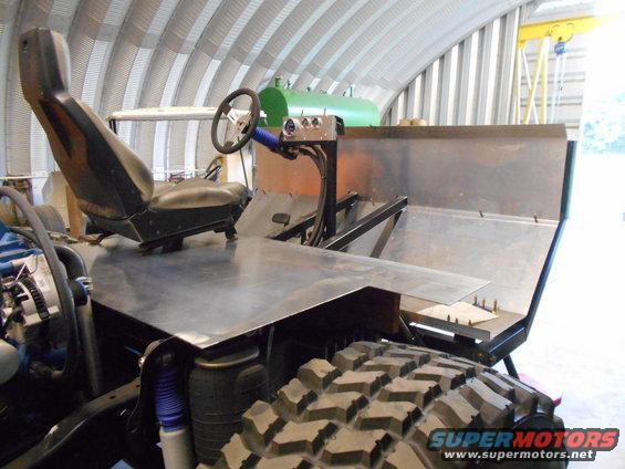 custom off-road vehicle interior with bucket seat, steering wheel, and metal dashboard