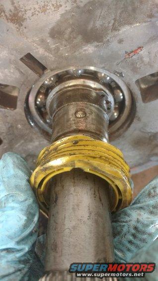 Bearing assembly with yellow plastic ring and gloved hands