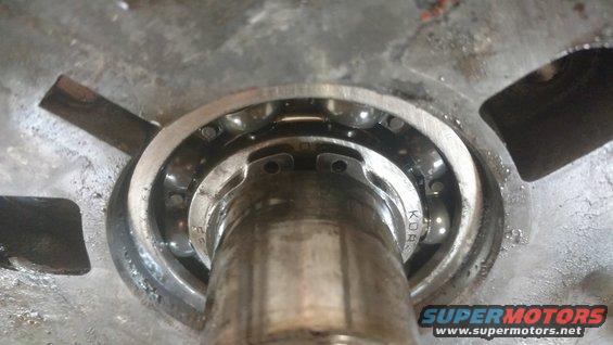 Bearing with visible ball bearings and metal housing, text 'KOR' visible