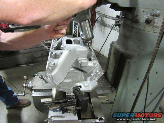 Aluminum intake manifold on a milling machine with a drill bit working on it