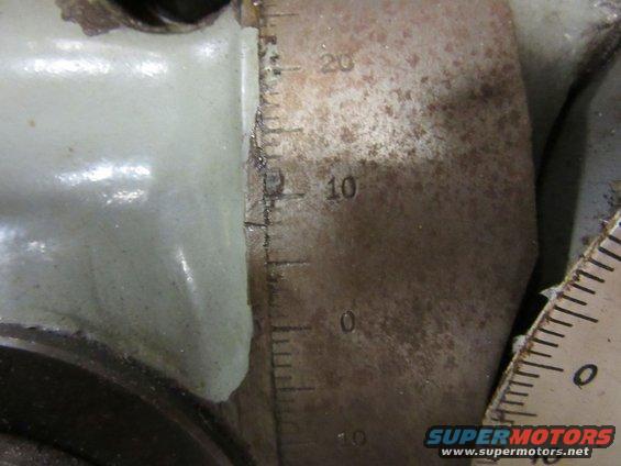 Close-up of a metal scale with markings for 0, 10, and 20, next to a light-colored component